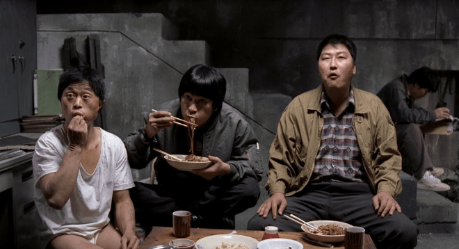 Déjeuner avec un suspect devant une série télé... en arrière plan, le flic de Seoul.